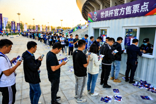 球迷在体育场外排队购买世俱杯官方纪念门票